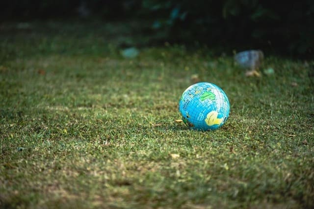 Un ballon gonflable qui représente la Terre est posé sur l’herbe