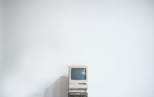 Premier ordinateur mac posé devant un mur blanc.