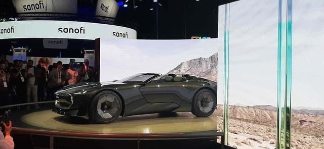 Une voiture sur un podium se trouve devant une publicité Sanofi au salon VivaTech 2022.
